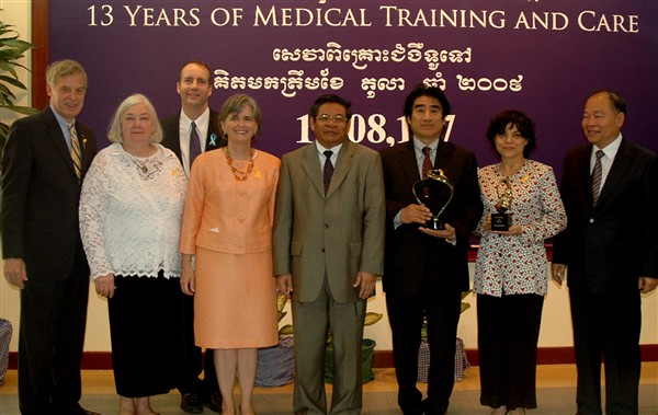 2009.11.5 シアヌーク病院100万人治療記念式典 記念写真：左から、ロバート・ゲンペル（病院理事）、パトリッシア・ゲンペル（ホープ・ワールドワイド）、ケビン・オブライエン（病院院長）、キャロル・ロッドレイ（駐カンボジア米国大使）、イム・チャイリー副首相、深見東州、デボラ・クリッシャー（ジャパン・リリーフ・フォー・カンボジア）、マン・ブンヘン保健大臣。